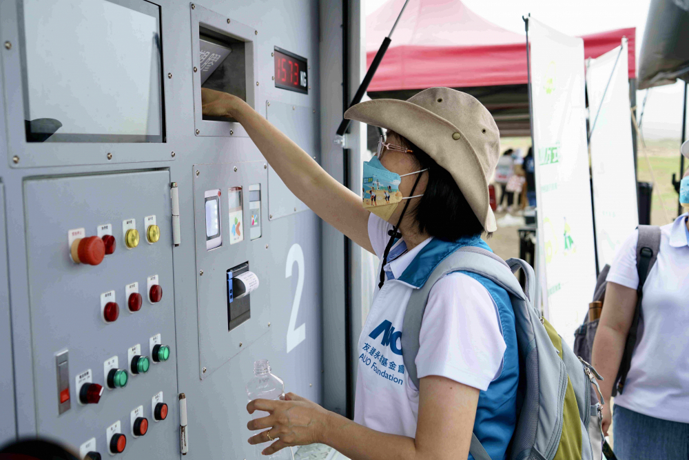 志工們將拾起的寶特瓶投入「好歸塑專車」，讓廢棄塑料空瓶可以直接粉碎、縮小體積，未來將可再製成購物袋、寶特衣、悠遊卡等生活用品
